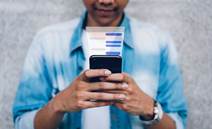 Man using chat message app on smartphone, in response to