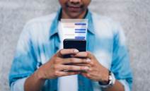 Man using chat message app on smartphone, in response to